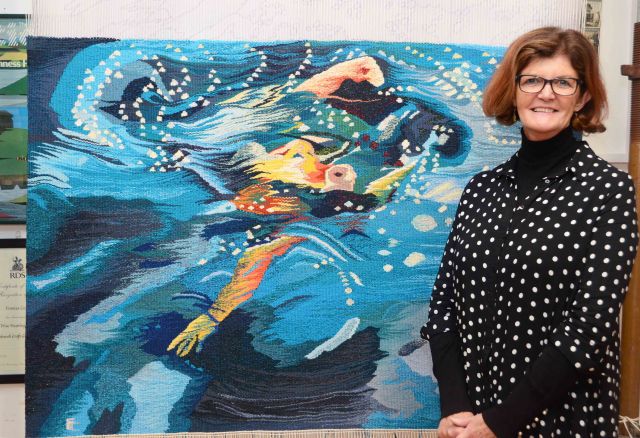 frances crowe in fornt of her latest tapestry titled Turmoil Measures 105 cm by 150 cm